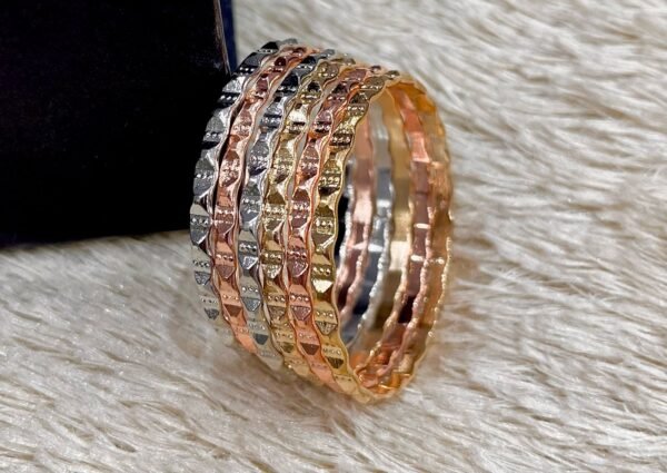 Set of tri‑tone bangles in silver, gold, and rose‑gold finishes